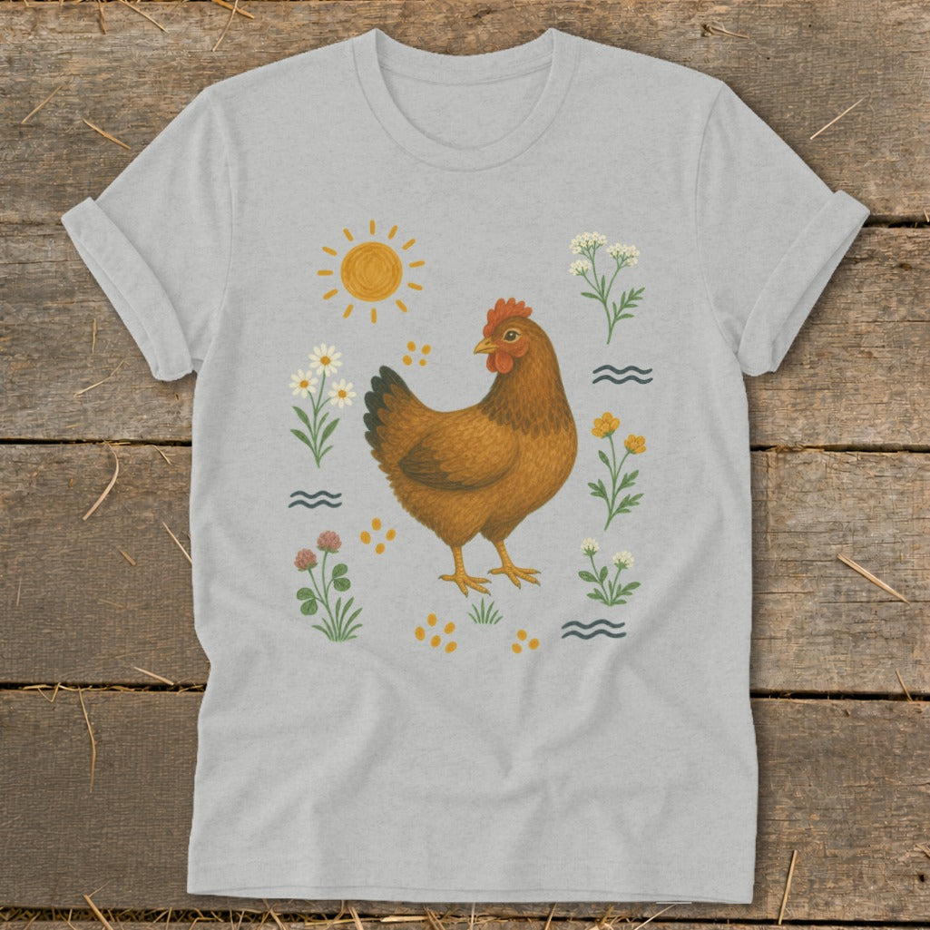Brown chicken surrounded by flowers, sun, and wavy lines on a light gray t-shirt.
