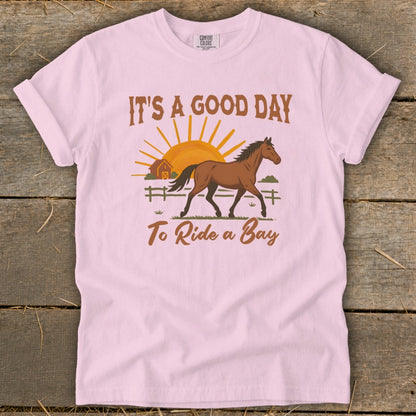Pink t-shirt with "It's a good day to ride a bay" and horse graphic.