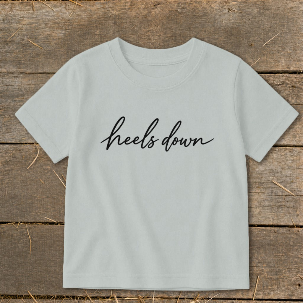 Light gray t-shirt with "heels down" text in black cursive lettering.