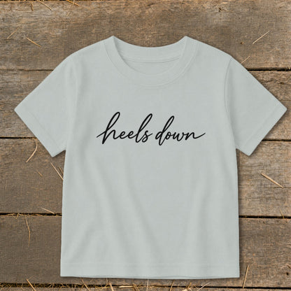 Light gray t-shirt with "heels down" text in black cursive lettering.