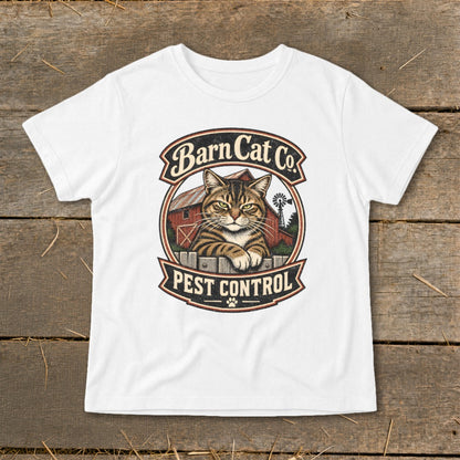 A white t-shirt featuring a vintage Barn Cat Co. pest control graphic laid flat on wood.