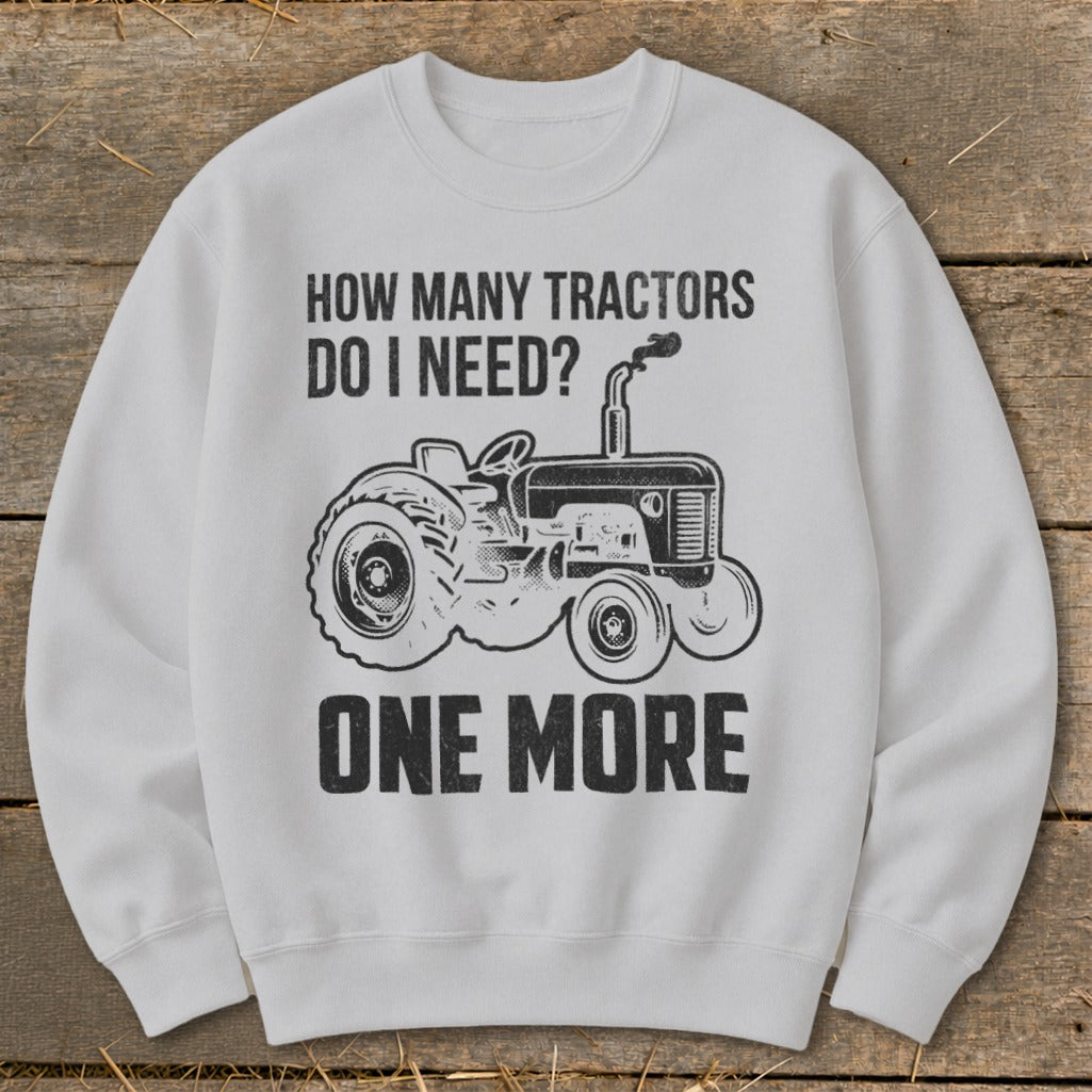 White sweatshirt with "How Many Tractors Do I Need? One More" and tractor graphic.