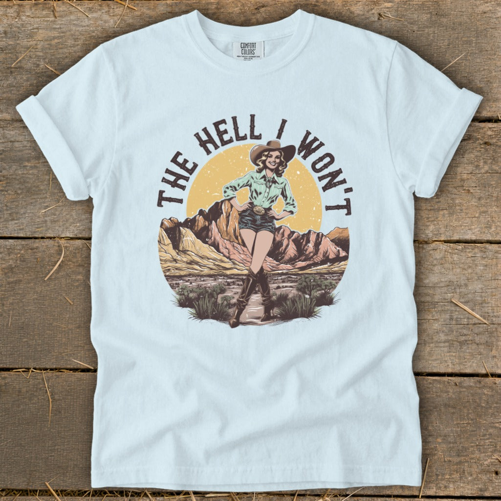 Cowgirl graphic with text "The Hell I Won't" on a light blue t-shirt.