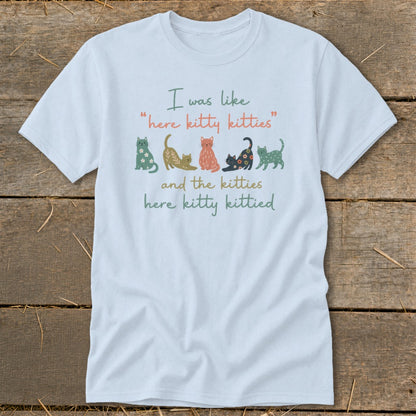 Light blue t-shirt with text and illustrated cats.