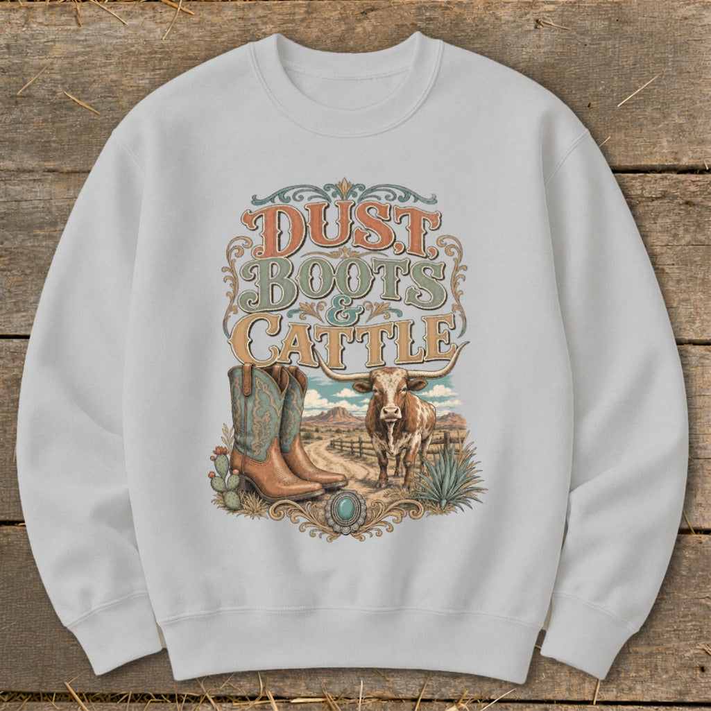 White sweatshirt with "Dust Boots & Cattle" graphic featuring boots, longhorn, and desert landscape.