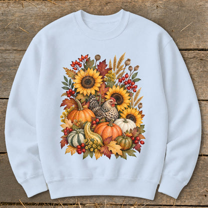 Light blue sweatshirt with a watercolor design of pumpkins, sunflowers, chicken, and fall foliage.
