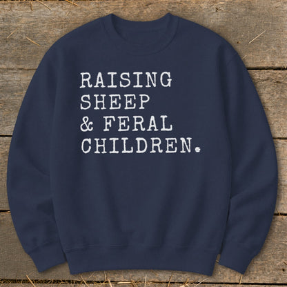 Navy sweatshirt with white text: Raising sheep & feral children.