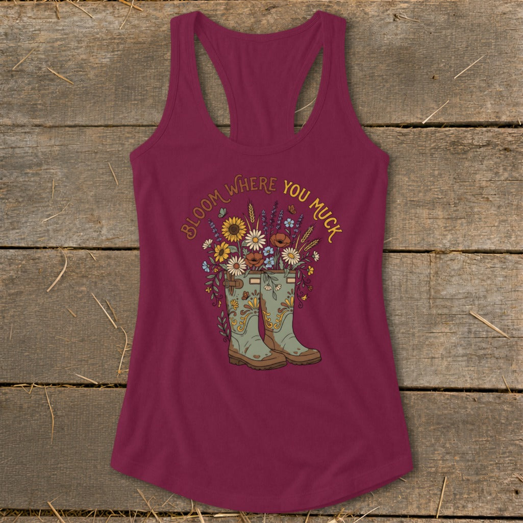 Maroon tank top with "Bloom Where You Muck" text and floral garden boots graphic.
