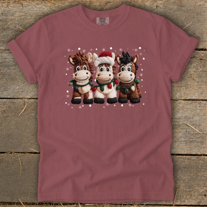 Three cartoon horses wearing holiday scarves and lights, one with a Santa hat.