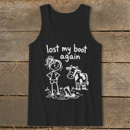 A black tank top featuring white stick-figure art of a girl looking at her boot stuck in mud alongside a cow, with the text lost my boot again above them.