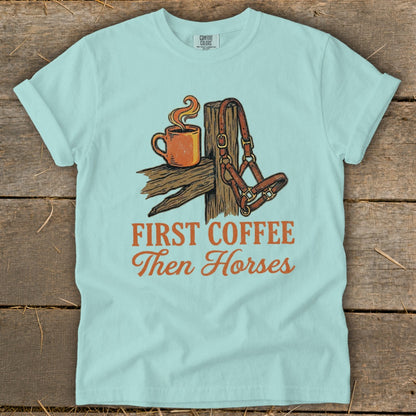 Light blue t-shirt with "First Coffee Then Horses" text and horse halter.