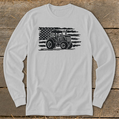 Tractor silhouette on distressed American flag graphic on a white long-sleeve shirt.