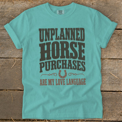 Teal t-shirt with "Unplanned Horse Purchases Are My Love Language" text and horseshoe graphic.