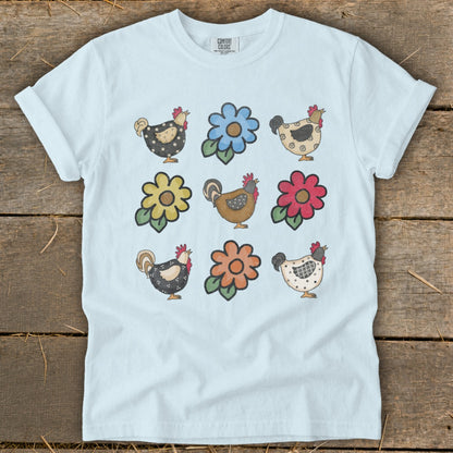 Light blue t-shirt with a pattern of roosters and flowers.