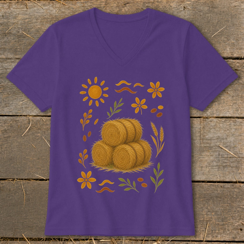 Purple v-neck t-shirt with a central illustration of three hay bales surrounded by autumn motifs.