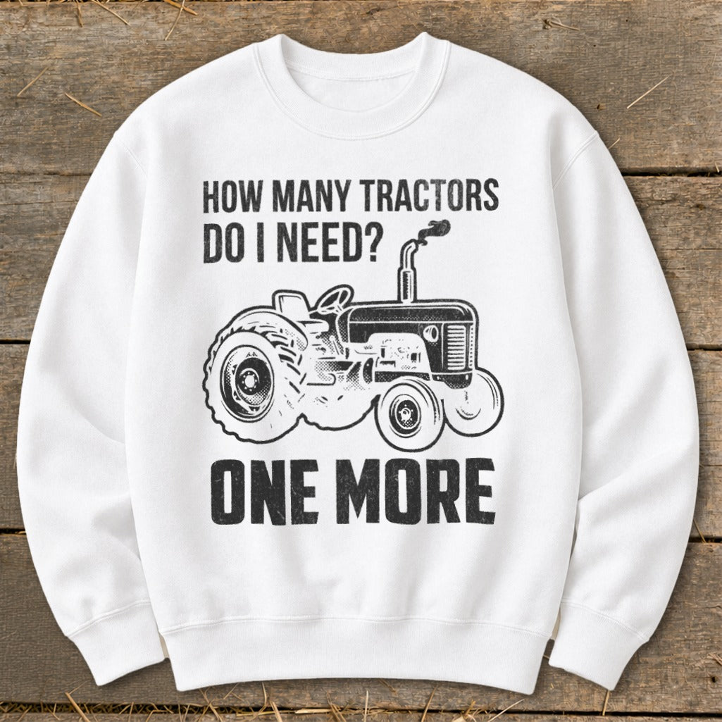 White sweatshirt with black graphic of tractor and text "HOW MANY TRACTORS DO I NEED? ONE MORE".