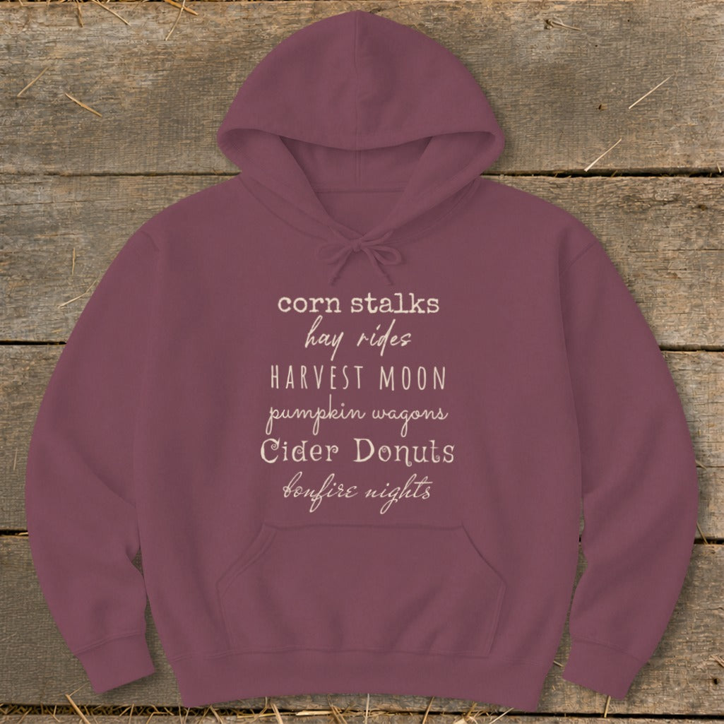 Maroon hoodie with "corn stalks hay rides HARVEST MOON pumpkin wagons Cider Donuts bonfire nights" text.