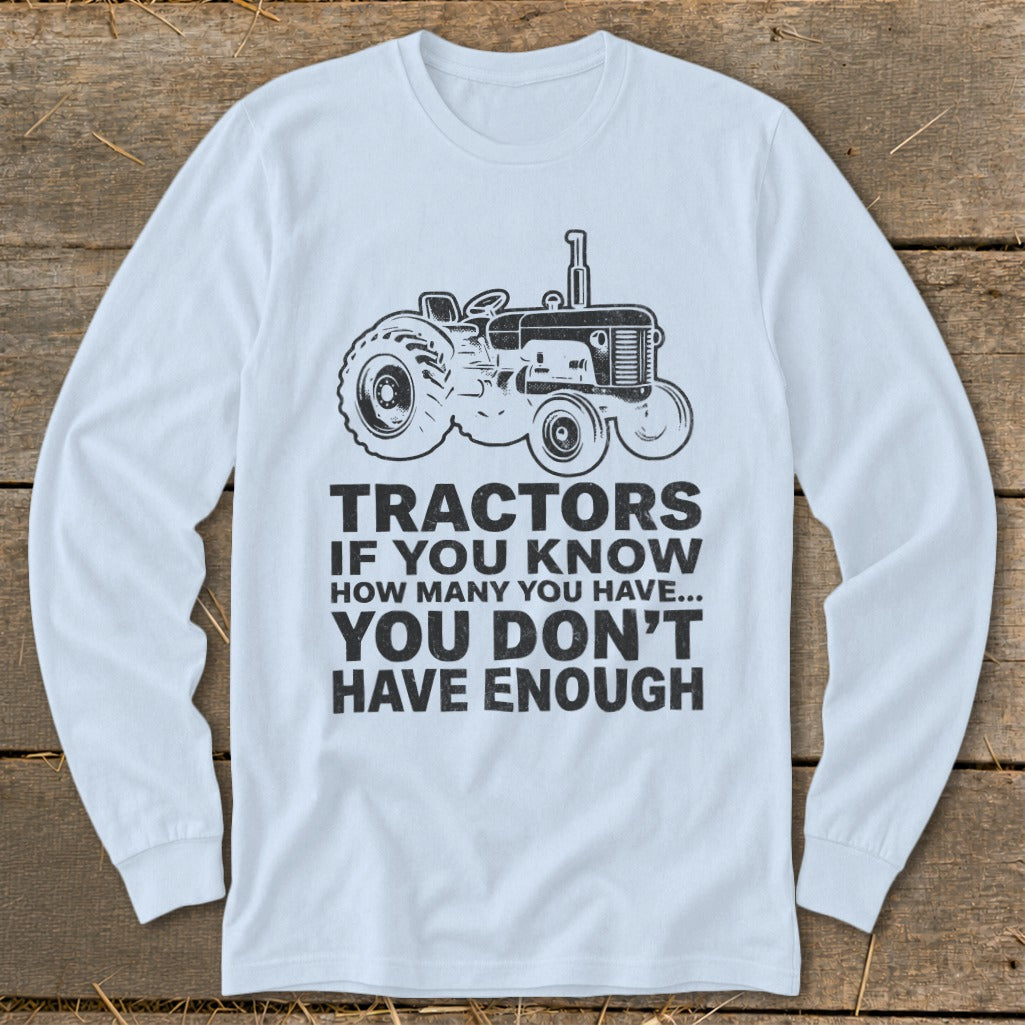 White long-sleeve shirt with tractor graphic and text about tractors.