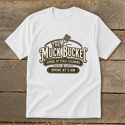 White t-shirt with "The Muck Bucket School of Stall Cleaning Opens at 5 AM" logo.