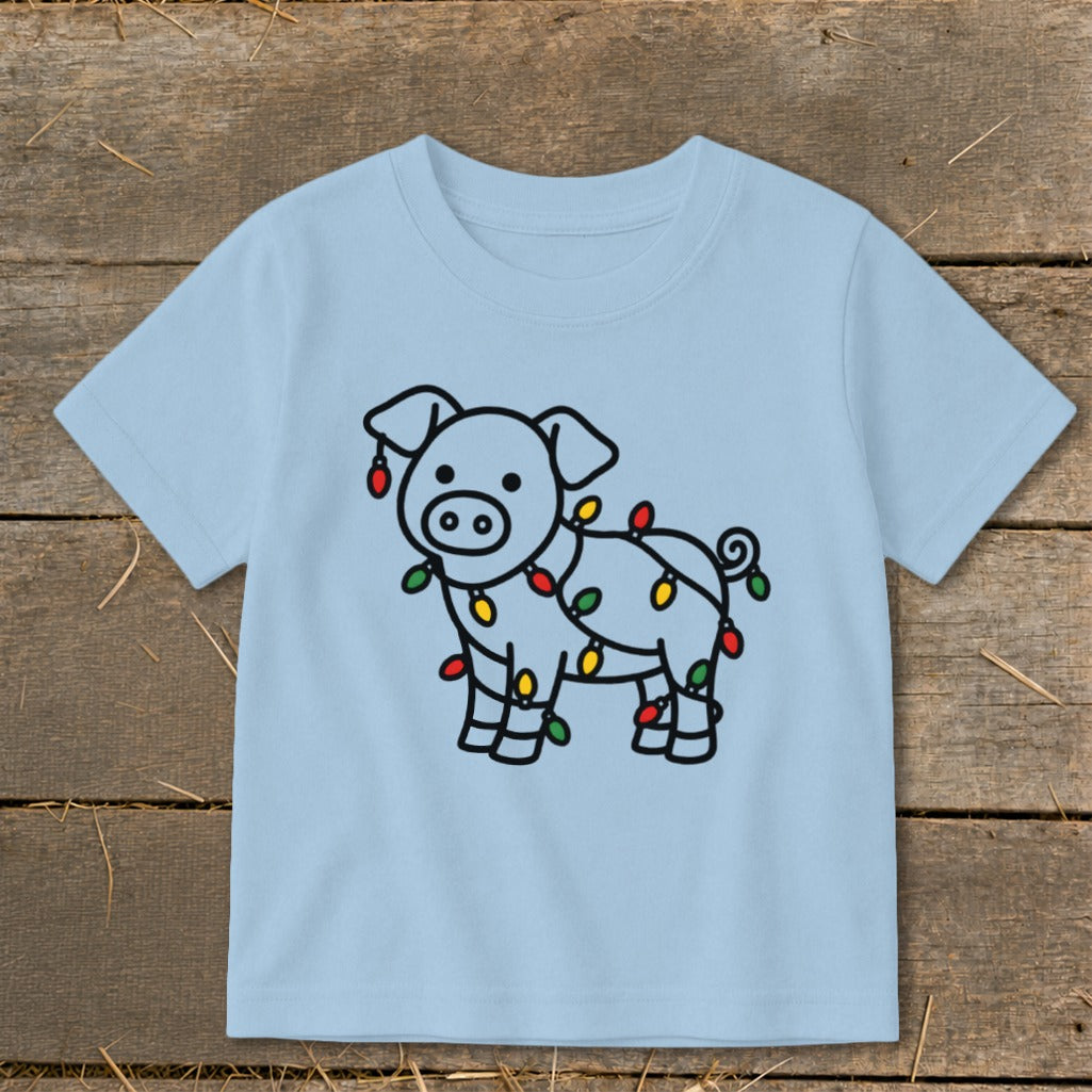 Light blue children's t-shirt featuring a cartoon pig wrapped in colorful Christmas lights.