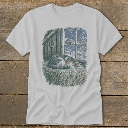 T-shirt with a sleeping cat on hay, looking out a window at a snowy scene.