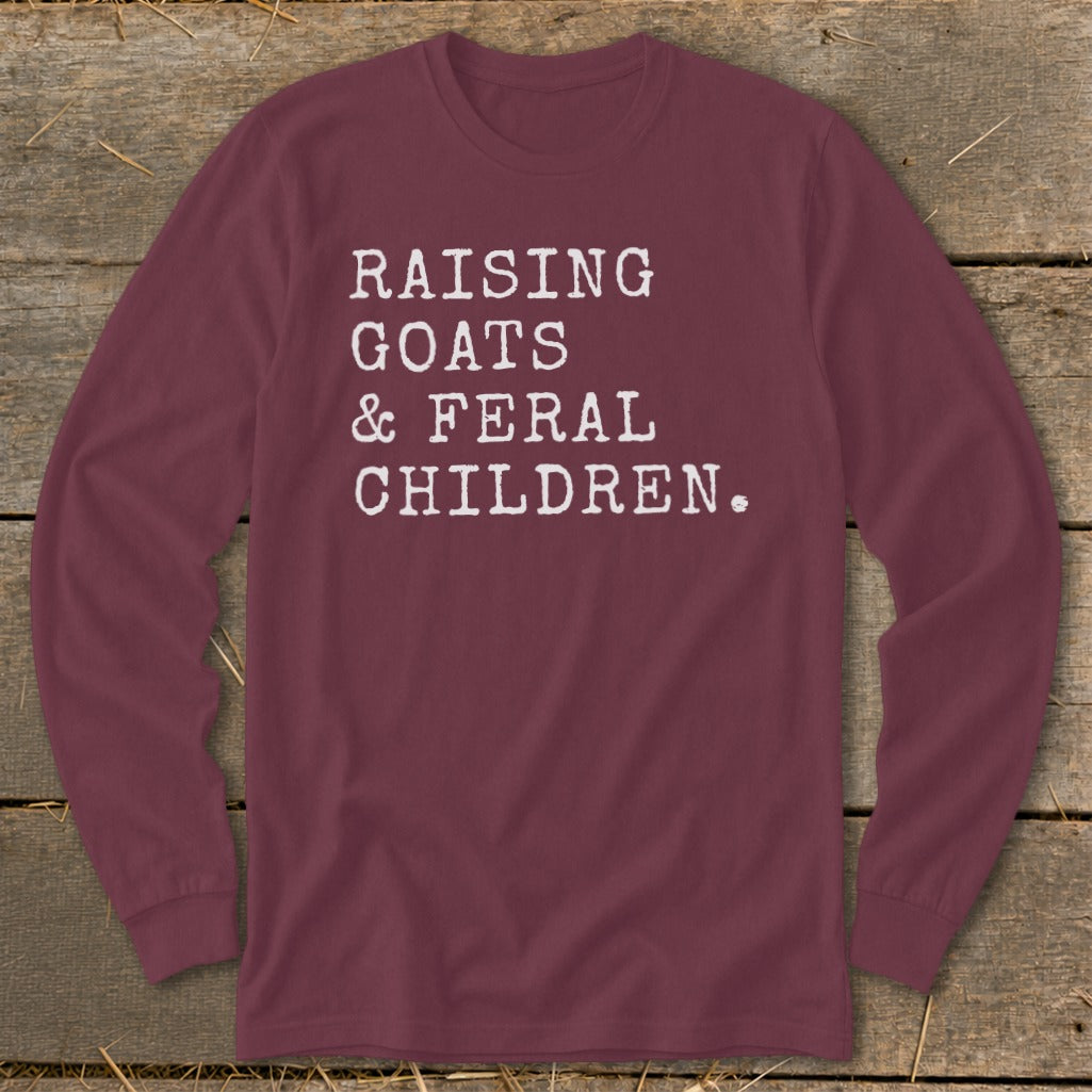 Maroon long-sleeve shirt with white text: Raising goats & feral children.