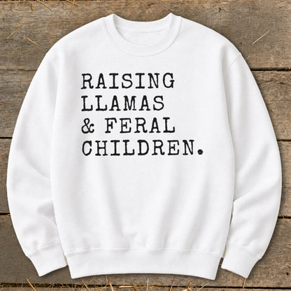 White sweatshirt with black text: "RAISING LLAMAS & FERAL CHILDREN."