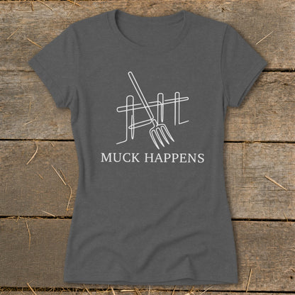 Dark gray t-shirt with white line art of pitchfork and fence, text "MUCK HAPPENS".
