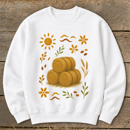 White sweatshirt with a stack of hay bales and autumn-themed graphics.