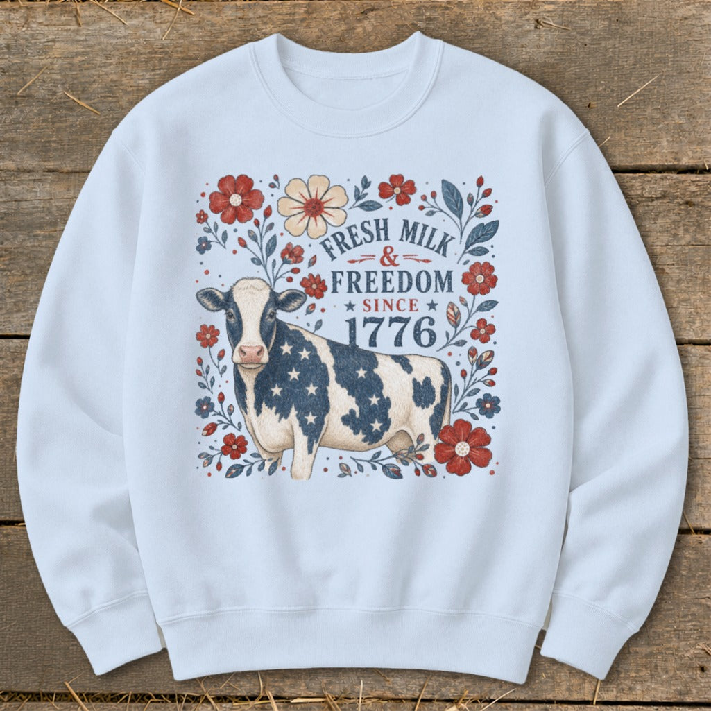 Cow with stars and stripes on a sweatshirt, with text "Fresh Milk & Freedom Since 1776".