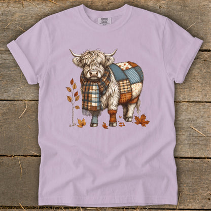 Quilted Highland cow wearing a plaid scarf, with autumn leaves.