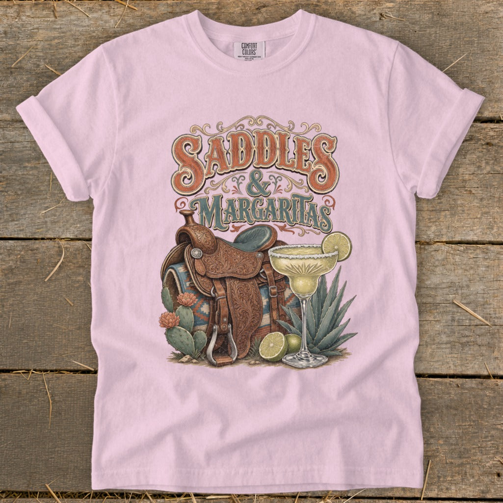 Pink t-shirt with "Saddles & Margaritas" design featuring a western saddle, margarita, and cacti.