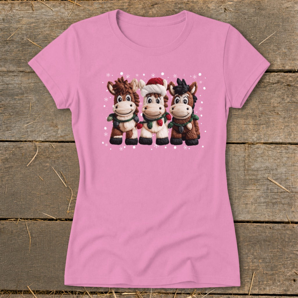 Pink t-shirt with three cartoon horses wearing scarves and one with a Santa hat.