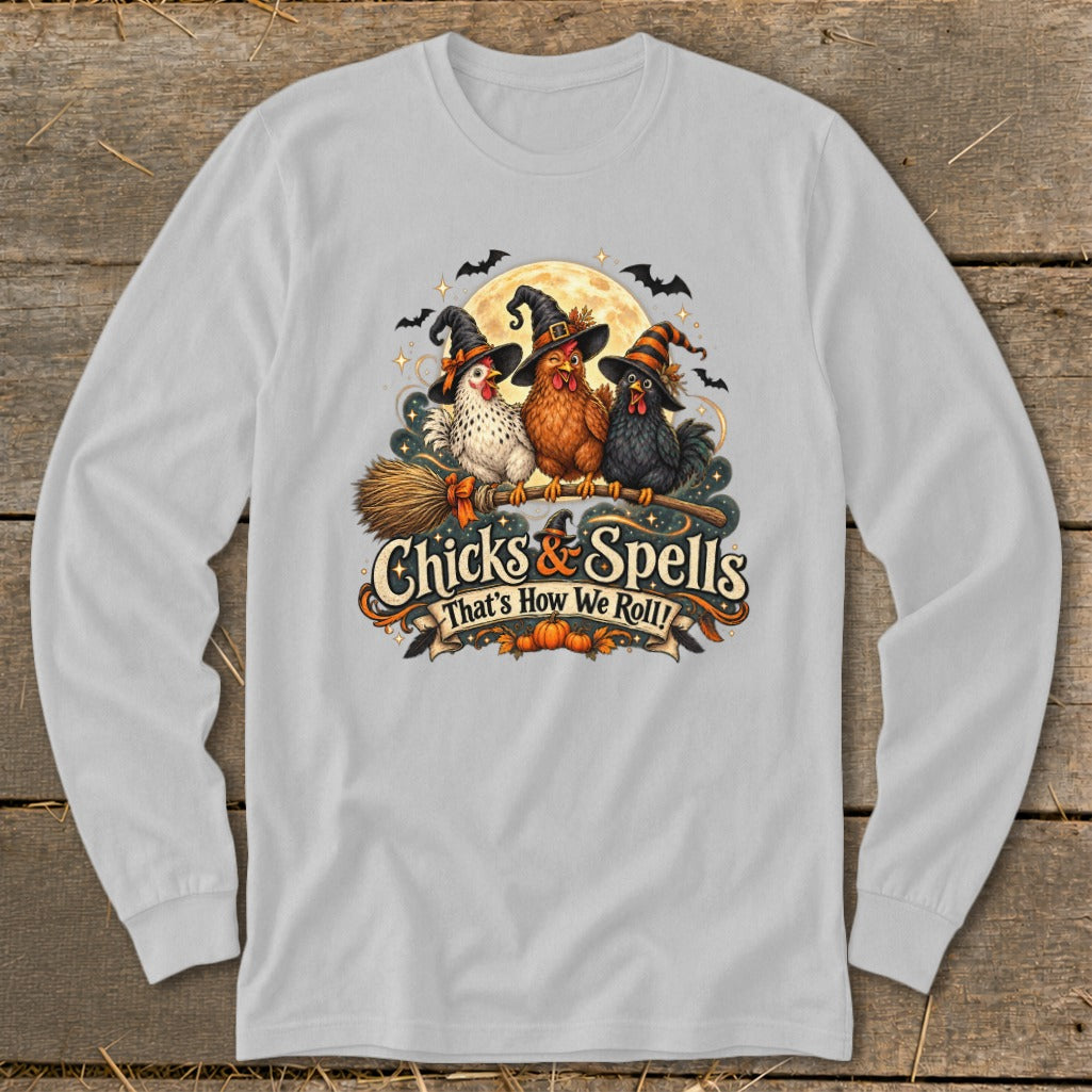 Three chickens in witch hats ride a broomstick under a moon, with text "Chicks & Spells".