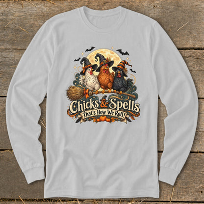 Three chickens in witch hats ride a broomstick under a moon, with text "Chicks & Spells".