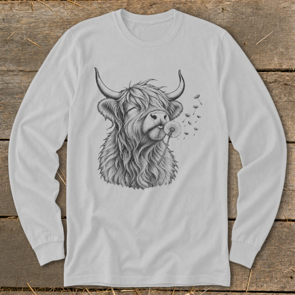 Line drawing of a fluffy Highland cow blowing on a dandelion on a long-sleeved shirt.