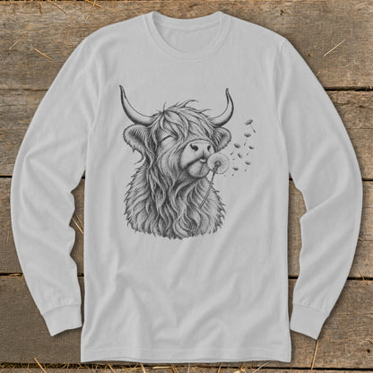 Line drawing of a fluffy Highland cow blowing on a dandelion on a long-sleeved shirt.