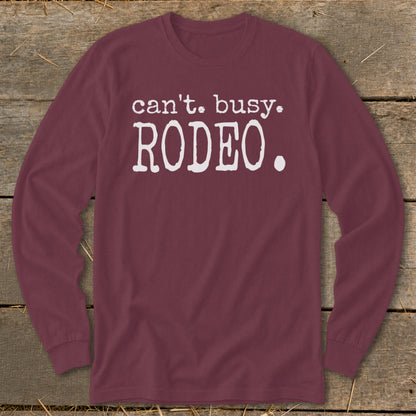 Maroon long-sleeve shirt with white text reading "can't. busy. RODEO.".