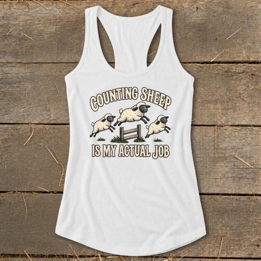White tank top with graphic of jumping sheep and text "Counting Sheep Is My Actual Job".