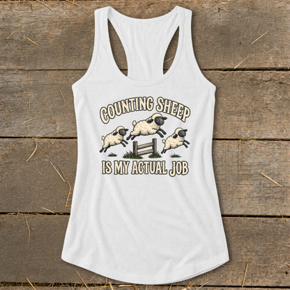 White tank top with graphic of jumping sheep and text "Counting Sheep Is My Actual Job".