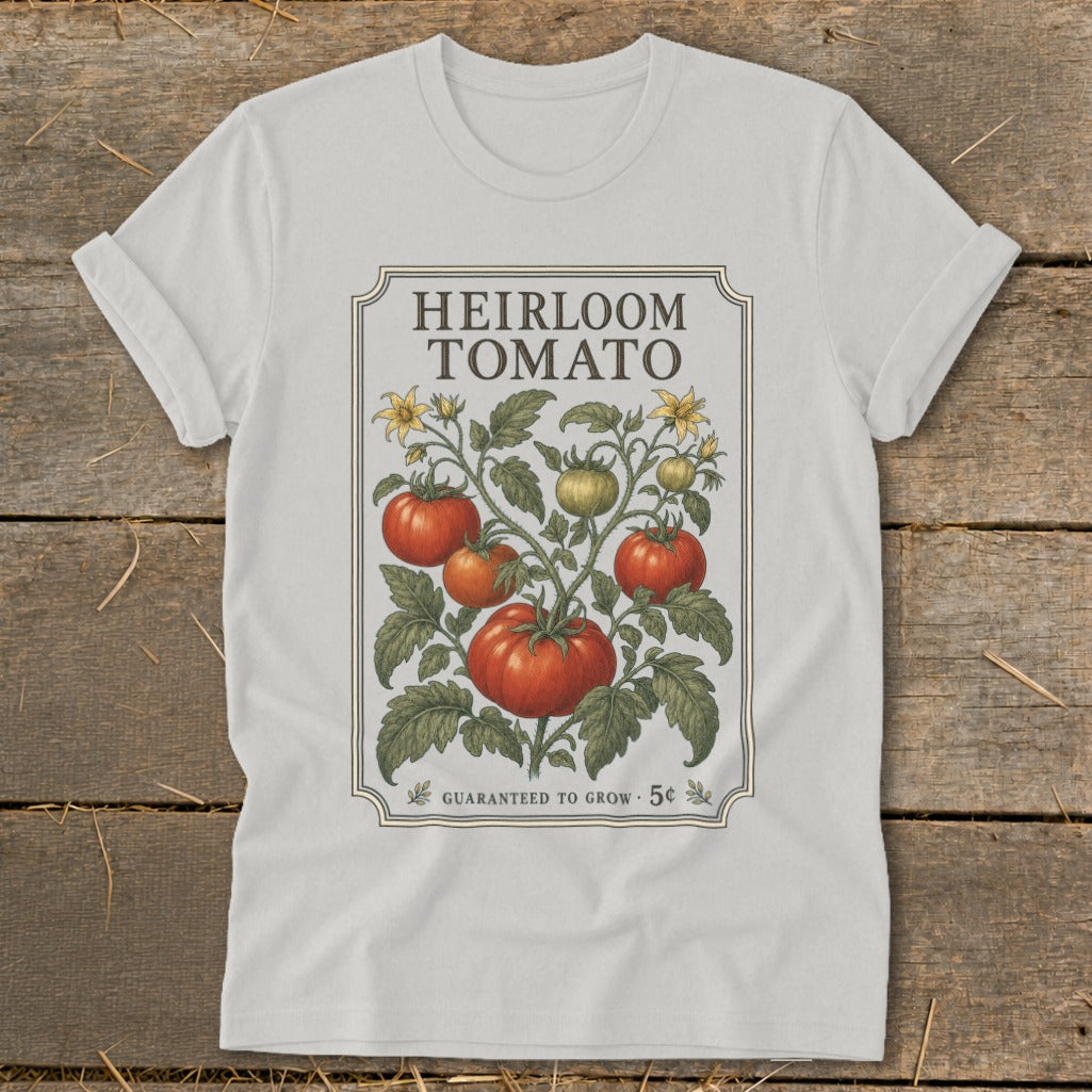White t-shirt with "Heirloom Tomato" design featuring vintage tomato plant illustration and "Guaranteed to Grow 5c".