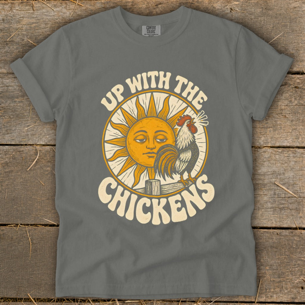 Gray t-shirt featuring a retro graphic of a rooster crowing beside a sleeping sun and the text Up With The Chickens.