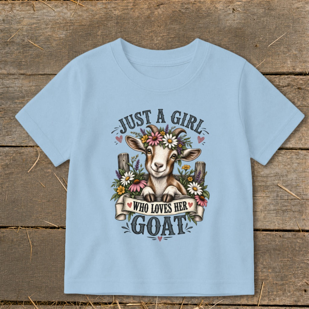 Light blue t-shirt with a drawing of a goat wearing a flower crown, with text "Just a girl who loves her goat".