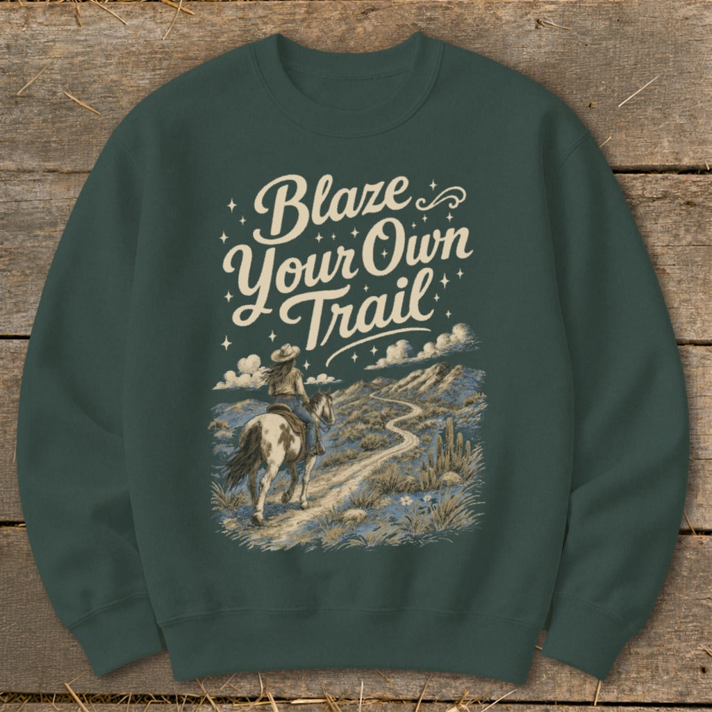 Dark green sweatshirt with "Blaze Your Own Trail" text and equestrian desert scene graphic.