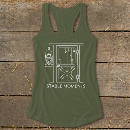 Olive green tank top with white line drawing of a stable door and lantern, reads "STABLE MOMENTS."