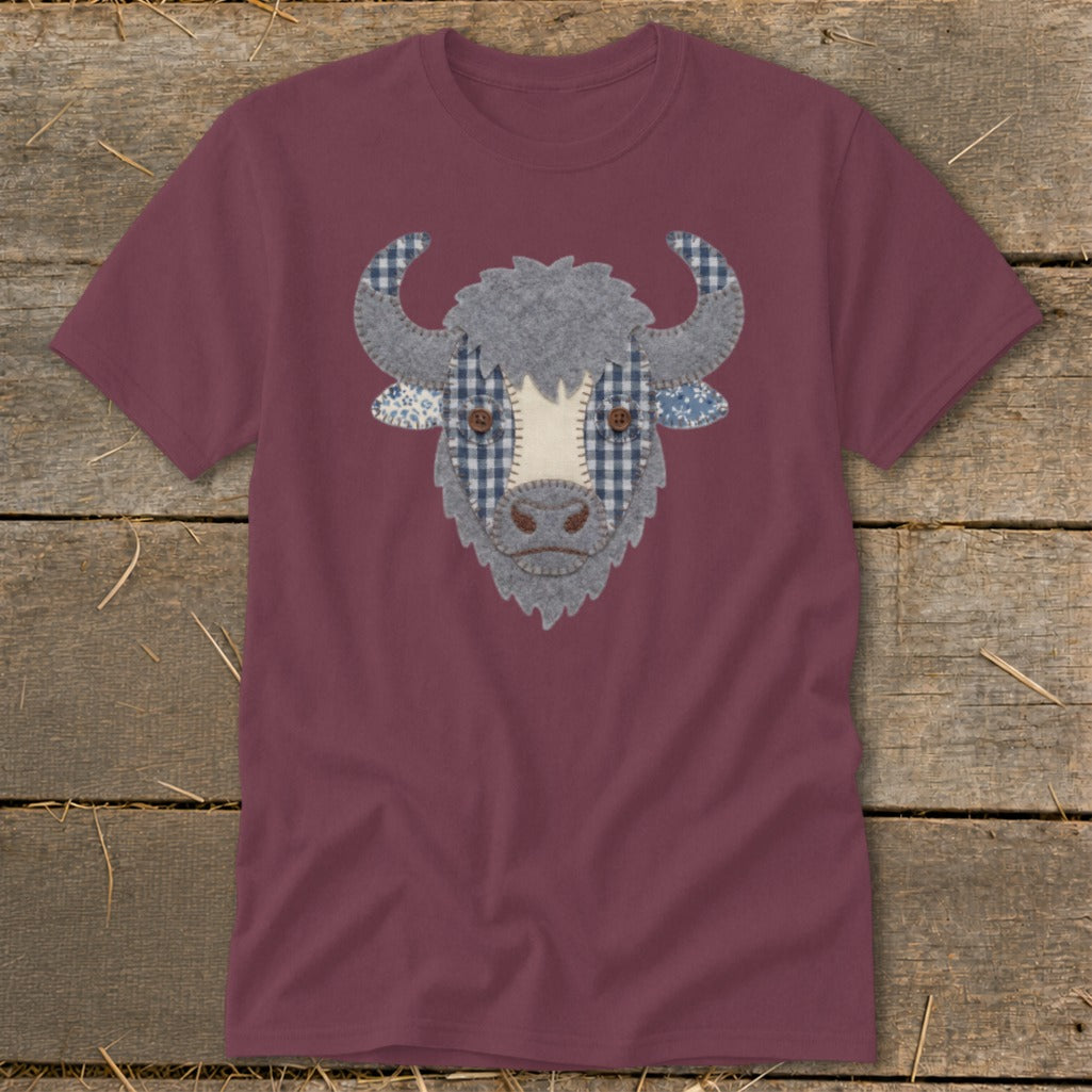 Burgundy t-shirt with a fabric applique of a buffalo head with plaid details.