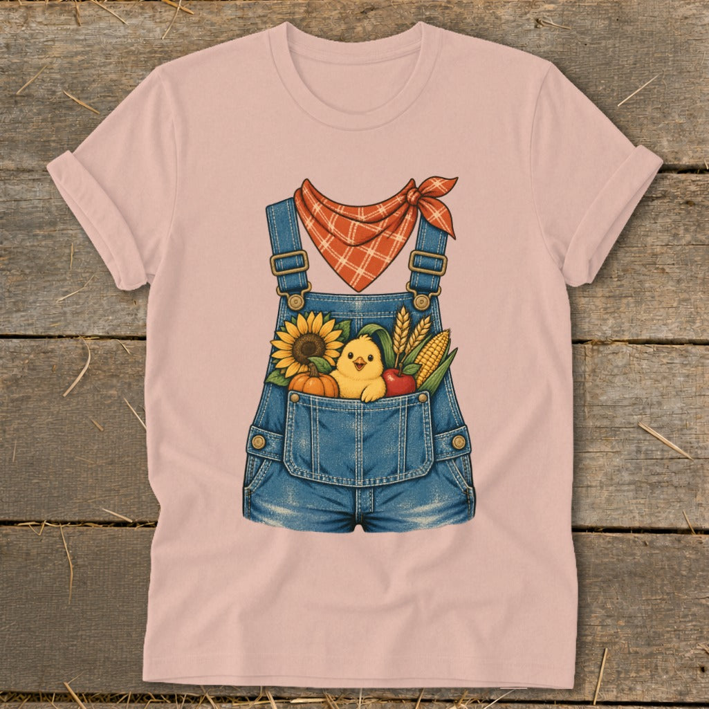 Pink t-shirt with denim overalls graphic, featuring a chick and fall harvest in the pocket.