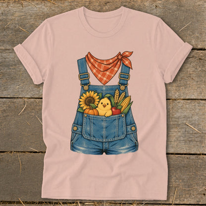 Pink t-shirt with denim overalls graphic, featuring a chick and fall harvest in the pocket.