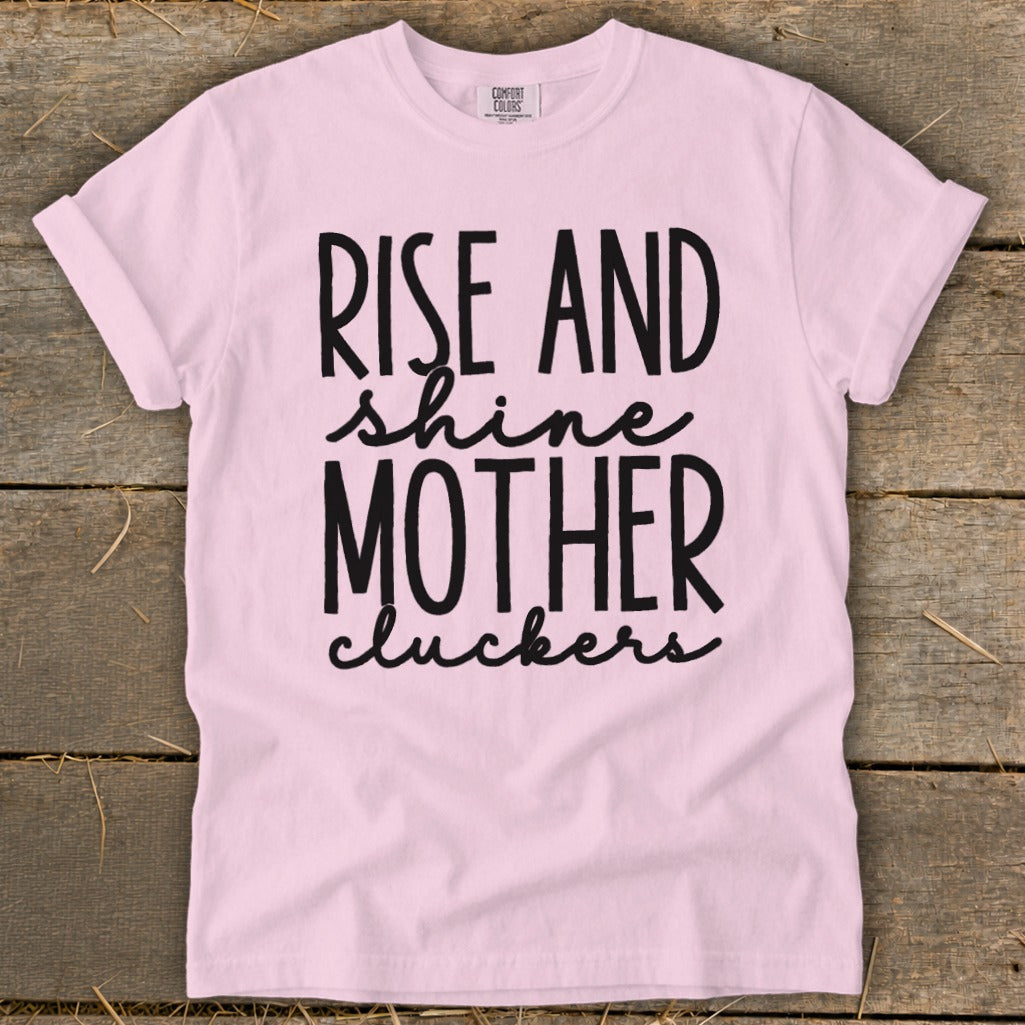 Pink t-shirt with black text "RISE AND shine MOTHER cluckers".