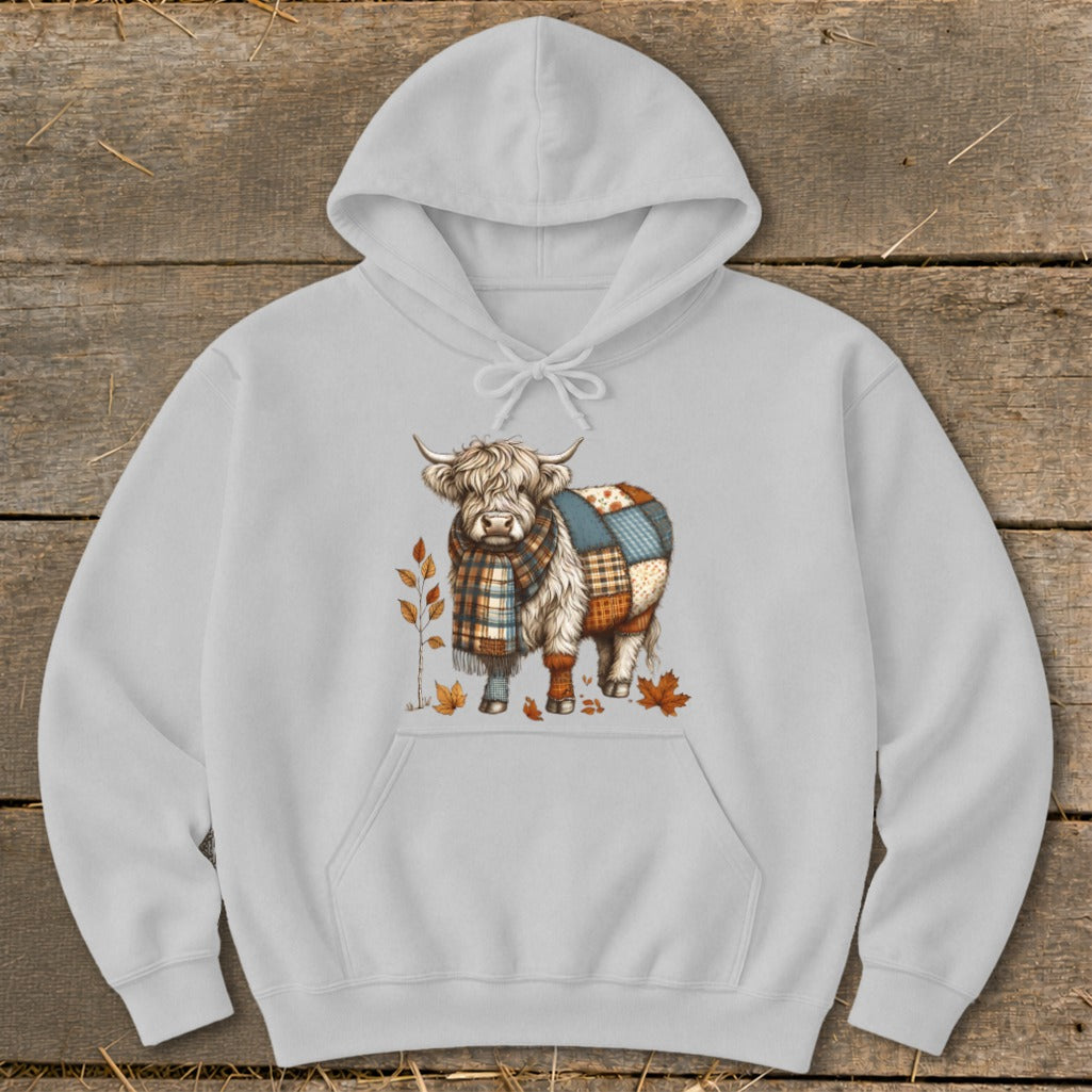 Grey hoodie with a Highland cow graphic wearing a plaid scarf and patchwork body.